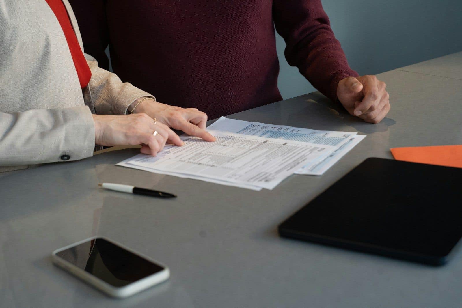 Two people reviewing a printed form together at a table